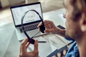 closeup-freelance-worker-using-headphones-office